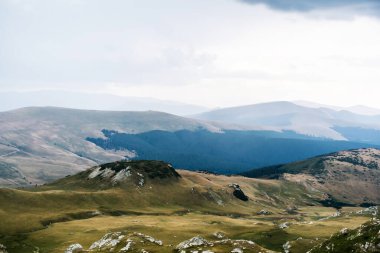 Dağlar, yeşil tepeler ve bulutlu gökyüzü, Transalpina yolu, Romanya.