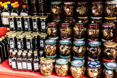 BUCHAREST, ROMANIA - 19 Ağustos 2023: Romanya geleneksel yiyecek ve içeceği, turşu kavanozları, vişne reçeli ve alkollü şişeler.