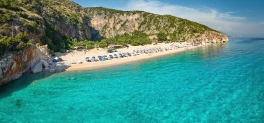Gjipe Sahili. Panoramik, deniz tarafından hava manzaralı. İyon Denizi 'nin berrak suları, temiz bir çakıl taşı plajı ve yanında zeytin koruluğu olan etkileyici bir kanyon. Arnavutluk 'un en iyi plajı