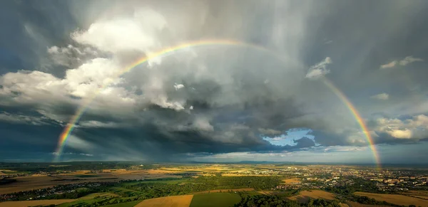 農地の上に虹 嵐の残骸 劇的な空 成熟したトウモロコシ畑 背景の町や丘 気象現象の空中パノラマビュー — ストック写真