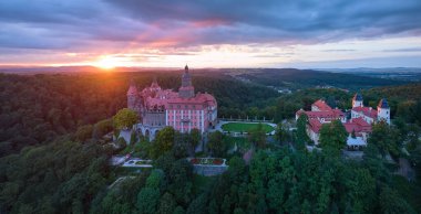 Panoramik, Ksiaz Şatosu, Schloss Frstenstein 'ın akşam hava manzarası. Dramatik bir gökyüzüne karşı ormanla çevrili bir kayanın üzerinde duran güzel bir kale. Polonya