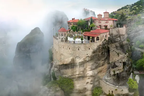 ギリシャを旅するテーマ メトロラホリーヴァレナ修道院は 青空に対して朝霧から上昇します 驚くべき神秘的な風景 ユネスコの遺産 メトロラ山脈 テッサリー ギリシャ ストックフォト