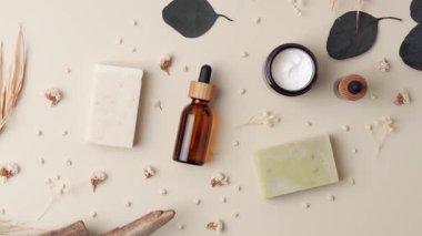 Pastel bej arka planda sabun ve çiçekli kozmetik cilt bakım ürünleri. Düz yat, boşluğu kopyala.