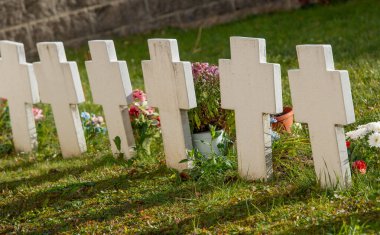 Terk edilmiş mezarlıkta mermer haçlar.