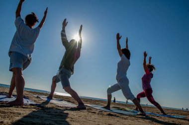 Rimini Italy August 7 2016: Group of people doing gymnastics at sunrise on the beach