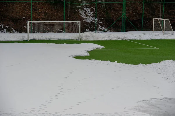 Synthetic soccer field covered with snow