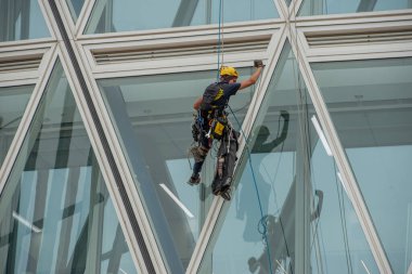 Milan İtalya 29 Haziran 2024: Koşumlu bir halat operatörü, bir binanın ön cephesine iniyor