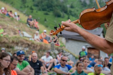 Bergamo Italy July 27, 2024: Musician performing in the mountains to raise awareness of respect for nature clipart