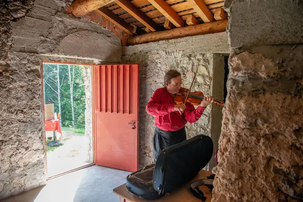 stock image Bergamo Italy August 7, 2024: Violinist performs in the mountains to raise awareness of respect for nature