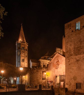 Porta Reale 'nin dış cephesi ve San Biagio di Finalborgo Kilisesi' nin çan kulesi olan antik duvarlar.