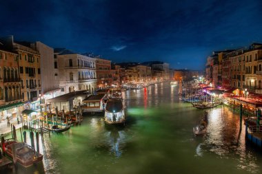 Venedik İtalya 9 Ekim 2024: Venedik 'teki Büyük Kanal' da tekneler gece. Rialto Köprüsünden Görünüm