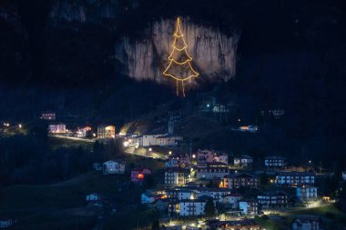 Cornalba village lighting with luminous tree on the rock clipart