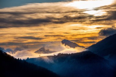 Gün batımında dağları kaplayan sis.