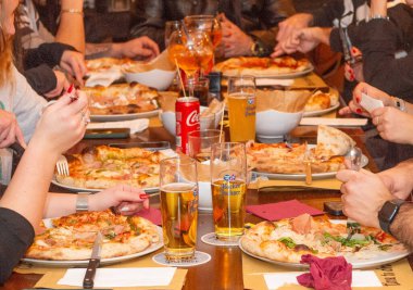 Bergamo İtalya 21 Aralık 2024: Pizza yiyen arkadaşlar grubu