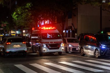 Işıkları ve sirenleri olan bir ambulans gece yoğun trafiğe giriyor. Yüksek kalite fotoğraf
