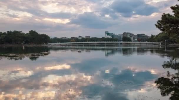 时间流逝 夕阳西下的云彩在平静的湖面上越过人行天桥 高质量的4K镜头 — 图库视频影像