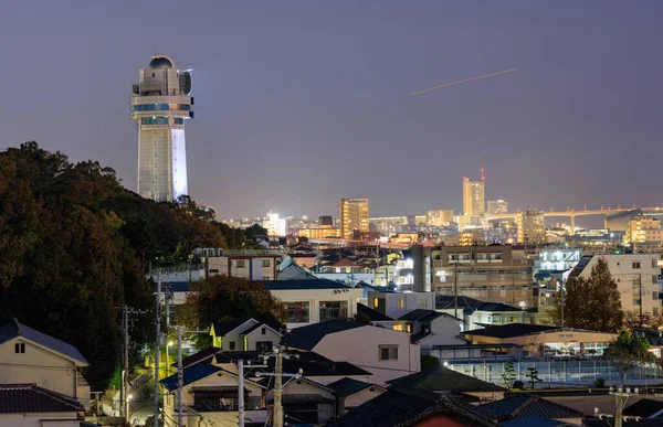Gece küçük şehrin ışıklarının üzerinde saat kulesi var. Yüksek kalite fotoğraf