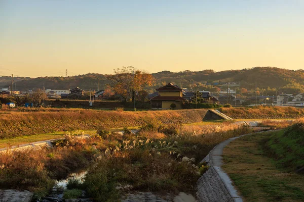 Nehirde sabahın erken saatlerinde altın ışık küçük Japon kasabasında bükülür. Yüksek kalite fotoğraf