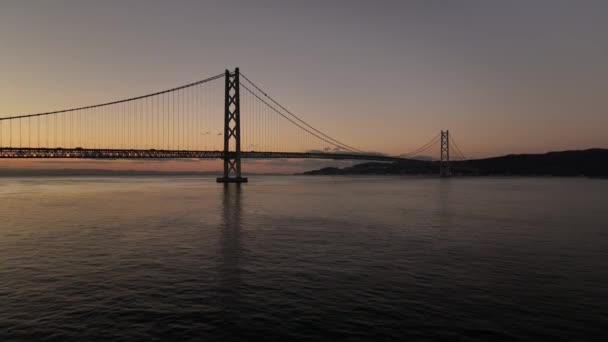 黎明时分 低空飞越水面 飞向长长的悬索桥 高质量的4K镜头 — 图库视频影像