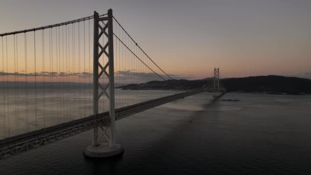 黎明时分在平静的水面上拉回长悬索桥 高质量的4K镜头 — 图库视频影像