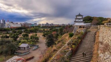 Fırtına bulutları gün batımından önce Akashi Kalesi Parkı 'nda hareket eder. Yüksek kalite 4k görüntü