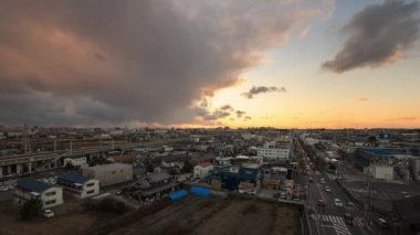 Gün geçtikçe hızlanan bulutlar, gün batımında küçük bir kasabadaki tren raylarının yakınındaki işlek yolda ilerler. Yüksek kalite 4k görüntü