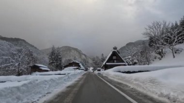 Shirakawa-go 'da kış günü kar küreği taşıyan biriyle geleneksel Japon gthe-zukuri evleri. Yüksek kalite 4k görüntü