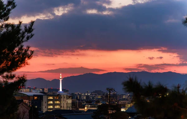 Orange sunset glow over Kyoto buildings and tower. High quality photo
