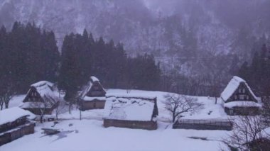 Şafak vakti Shirakawa yakınlarındaki geleneksel Gokayama dağ köyüne kar yavaşça yağıyor. Yüksek kalite 4k görüntü