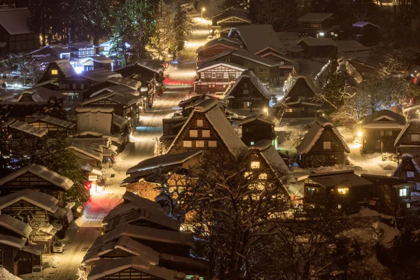 Well-lit main street down traditional Japanese village with winter snow. High quality photo
