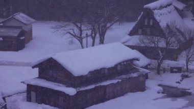 Şafakta, dağ köyündeki tarihi Japon gthe-zukuri evlerine kar yağar. Yüksek kalite 4k görüntü