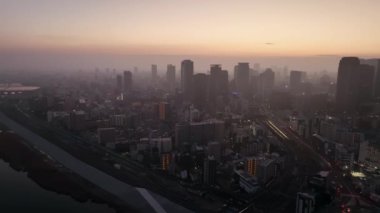 Şafak vakti modern kentteki gökdelenlerin sisli havadan görünüşü. Yüksek kalite 4k görüntü