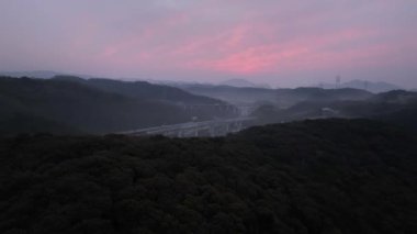 Dağ yolunda güzel pembe bulutlar ve şafakta sisli bir manzara. Yüksek kalite 4k görüntü
