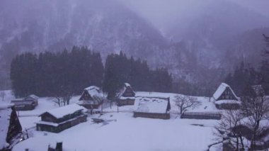 Snow and mist over traditional houses in rustic mountain village at dawn. High quality 4k footage