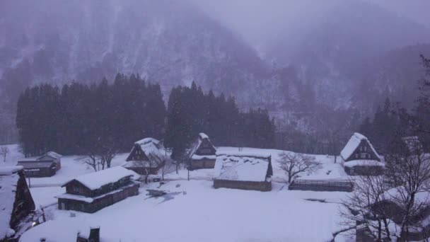 夜明けに素朴な山間の村の伝統的な家屋の上の雪と霧 高品質4K映像 — ストック動画