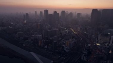 Tall buildings around Osaka Station in city center with haze at sunrise. High quality 4k footage