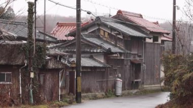 Rain falls in slow motion on old Japanese wooden house in rural village. High quality FullHD footage
