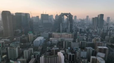 Osaka, Japan - January 7, 2023: Umeda Sky Building and construction cranes in city center at sunrise. High quality 4k footage