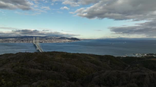 Stationary Aerial View Suspension Bridge Spanning Wide Straight Distant City — 비디오