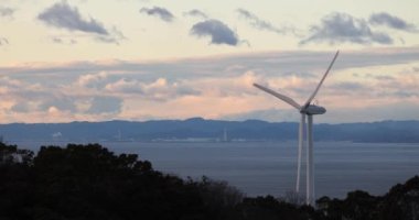 Beautiful sunset on single wind turbine generating green electricity on Awaji Island. High quality 4k footage