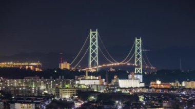 Evening traffic on Akashi Kaikyo Bridge and the sprawling residential town of Tarumi in Hyogo, Japan. 8K, Canon R5, RF 100-500L.
