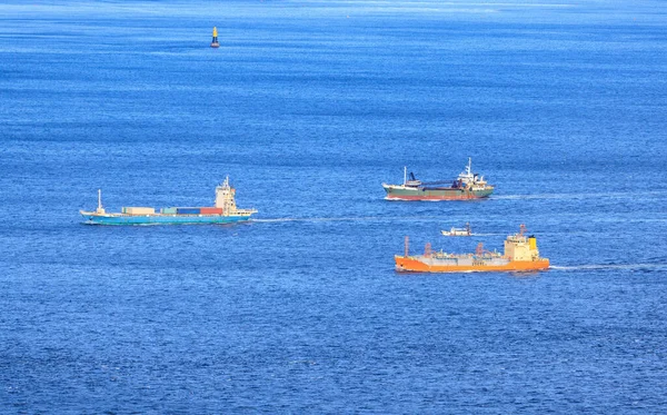 Small Fleet of Cargo Ships Sail through Shipping Lane in Calm Blue Sea. High quality photo