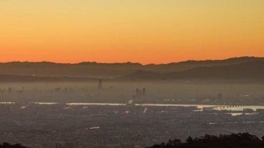 Heavy smog over Osaka and the Yodo River as sunrise glow hits city. Canon R5, RF 100-500L. High quality 4k footage