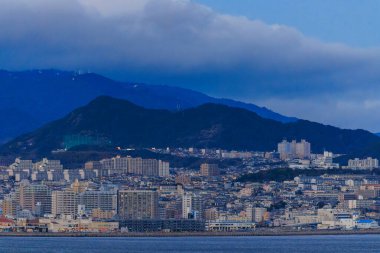 Tarumi, Japan - January 16, 2023: Large Apartment Complexes in Sprawling Coastal City by Mountains. High quality photo