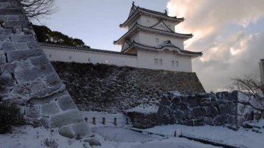 Snow covered Akashi Castle and modern tower on early winter morning. High quality 4k footage
