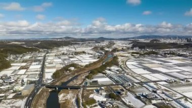 Aerial view of rice fields and roads in small Japanese farming village on winter day. High quality 4k footage