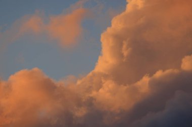 Fluffy pink clouds billow in early morning light. High quality photo