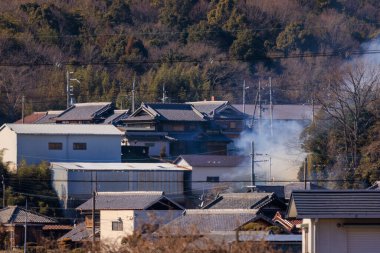 Smoke rises from houses in dense suburban neighborhood on sunny day. High quality 4k footage