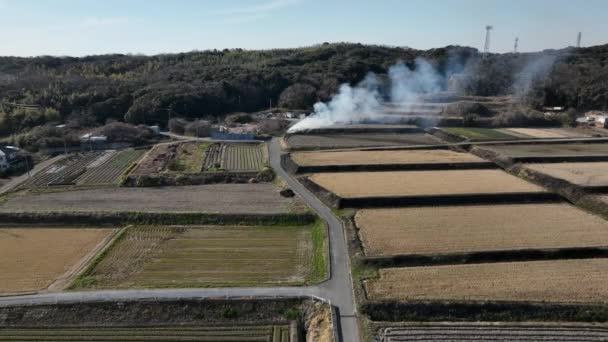 从空中俯瞰乡间小路穿过田野 烟从火中升起 高质量的4K镜头 — 图库视频影像