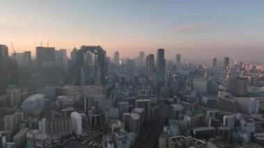 Aerial approach towards high rise office buildings in city at sunrise. High quality 4k footage